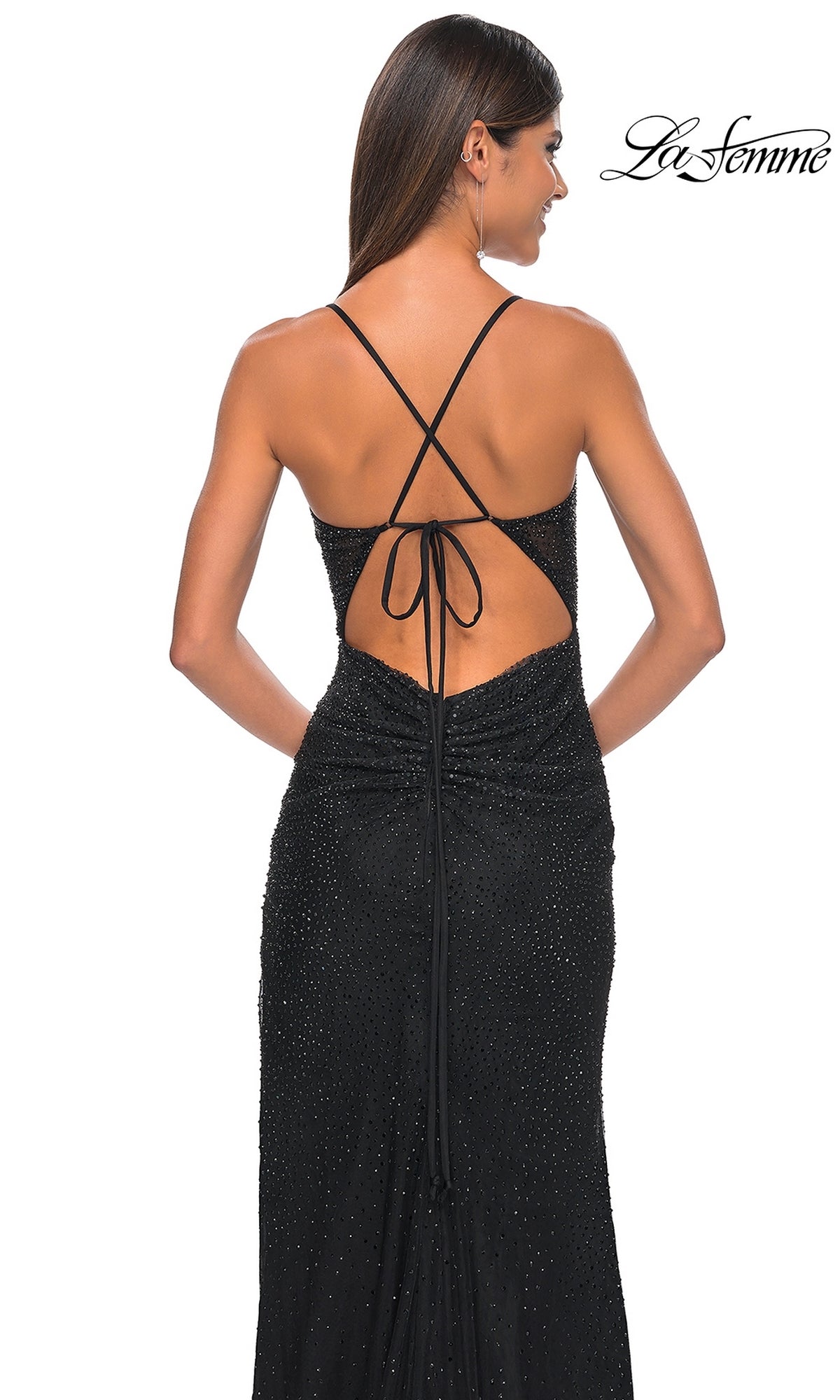 A woman is shown from the back wearing the La Femme Sheer-Corset Long Beaded Prom Dress 31701, featuring sparkly black fabric and crisscross tie straps. The La Femme logo is in the top right corner.